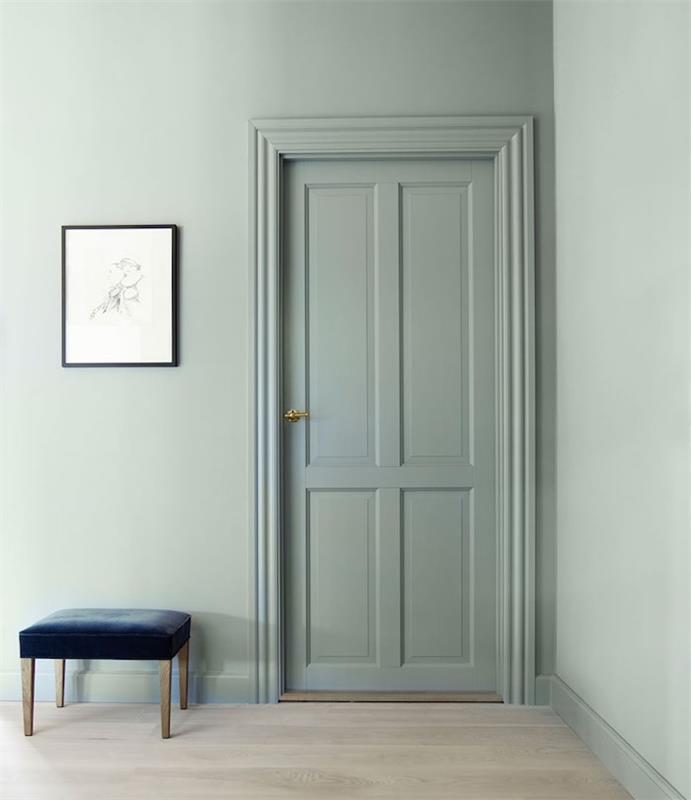 eleganten dizajn, stenske barve in pobarvana vrata s celadon verdigrisom, lahek parket, temno modri stol, grafično oblikovanje stenske dekoracije