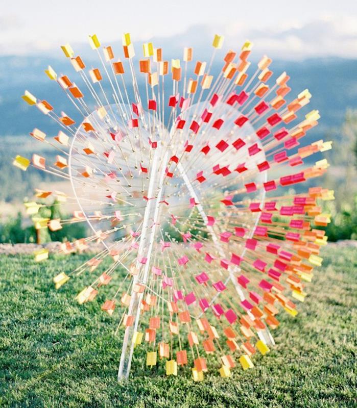 kelios spalvos rodyklės, einančios per didelę plastikinę širdį su svečių vardais, originalus vestuvių vietų planas