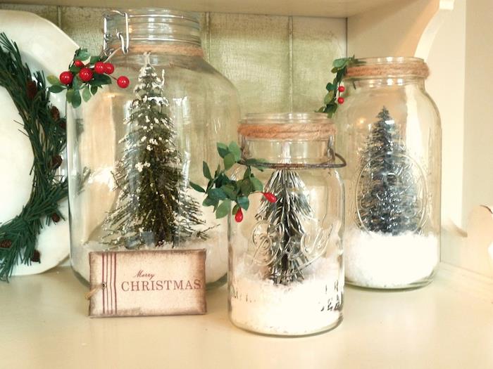 stiklinį indelį, papuoštą dirbtiniu sniegu ir eglutės figūrėlę indelyje, rankų darbo kalėdinę dekoraciją