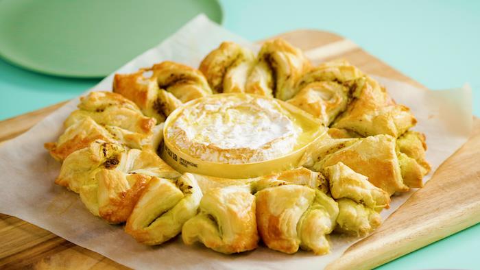 merkezinde pesto bükümleri ve kamembert ile lezzetli bir güneş turtası örneği, birkaç kişiyle paylaşmak için yemek
