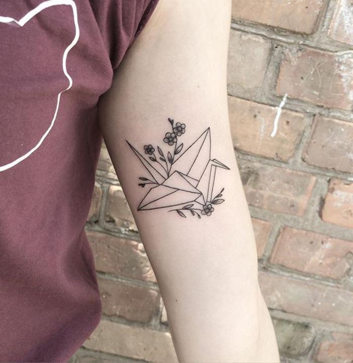 umirjena japonska tetovaža, navdihnjena z origami umetnostjo, ki vsebuje žerjava v geometrijskem slogu v paru z občutljivo cvetočo vejo