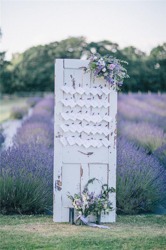 senovinės dėvėtos medinės durys su baltomis svečių etiketėmis ir gėlių puokštėmis, levandų laukas, originalus sėdimų vietų planas