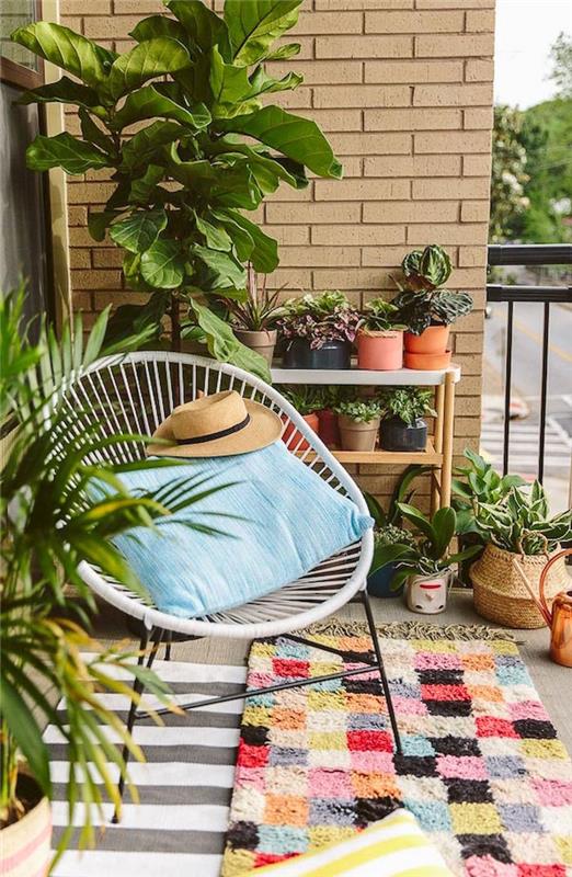 fotografija balkona, okrašenega z rastlinami in sadilnikom, beli gugalnik za teraso, pisana preproga za balkone