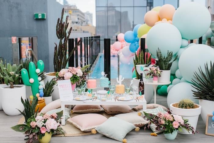 boemska elegantna večerna tema na terasi, baloni v pastelnih barvah in različnih velikostih., bela mizica in boemske elegantne blazine po tleh