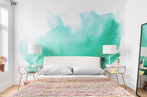 suaugusiųjų miegamojo išdėstymas, balta siena su vandens žalia dėme, balta patalynė, įvairiaspalvis lovos užtiesalas, dizainerių naktiniai staleliai, didelis stačiakampis veidrodis