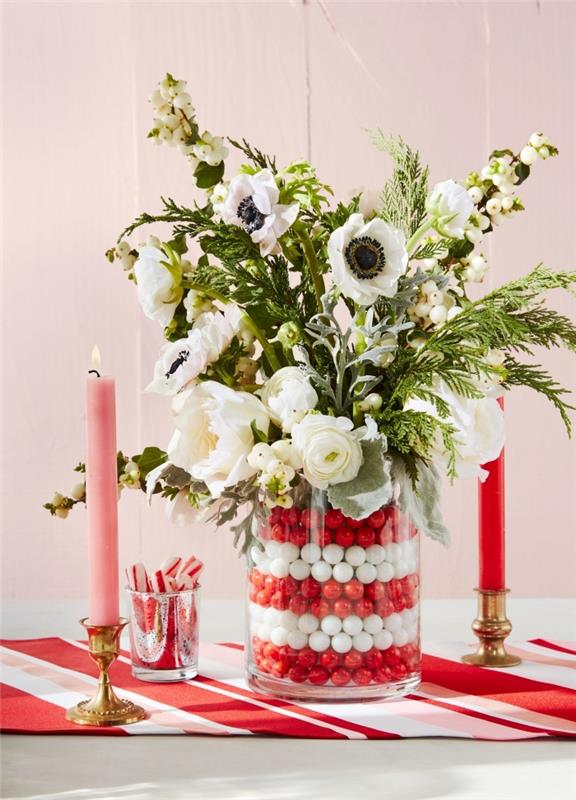 lengvas Kalėdų centras su gėlėmis, baltos ir žalios spalvos gėlių kompozicija stikliniame inde su raudonais ir baltais rutuliais