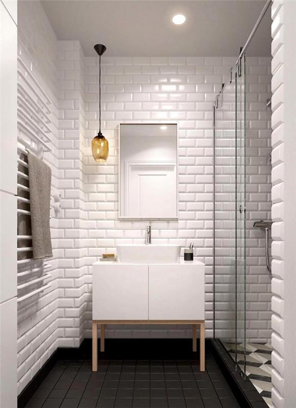 kopalniška omara z belim kvadratnim umivalnikom v kopalnici z belimi stenskimi ploščicami in sivim podom s 3D efektom tuširane ploščice