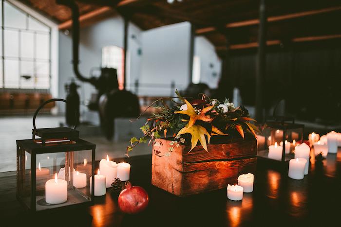 ideja o jesenskem poročnem dekorju z lesenim pladnjem s cvetjem kot osrednjim delom, svečami, črno lučjo, borovim stožcem