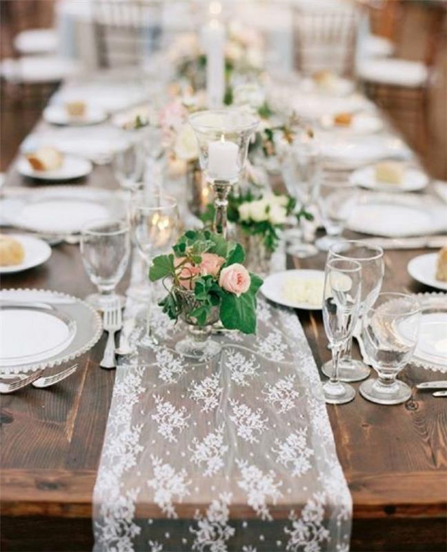 ideja za poročno dekoracijo, tekač za mizo iz čipke, rože v kozarcih, eleganten jedilni pribor, sveče, rustikalno elegantno poročno središče