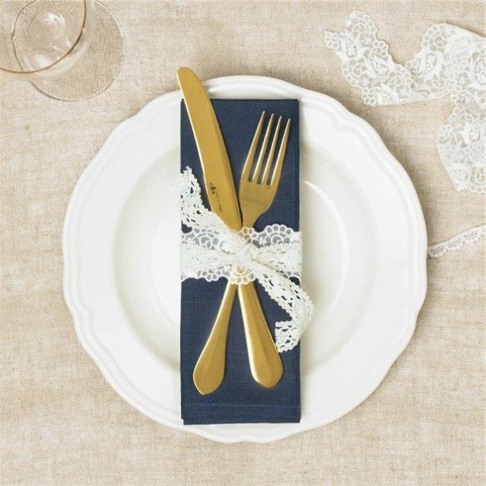 ideja za poročno dekoracijo, mornarsko modri prtiček, tesen pribor z belim čipkastim trakom, okras za mizo