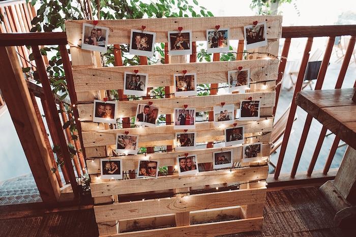 poceni poročni dekor, olupljene fotografije na leseni paleti z okrasom iz svetlega venca