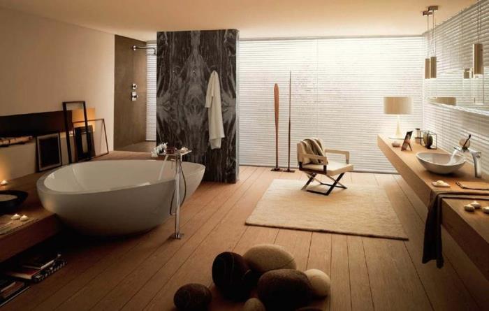 vonios kambario dekoro idėja, lentų grindys, kelios akmenukų pagalvėlės, laisvai stovinti vonia, ilgas medinis stalviršis