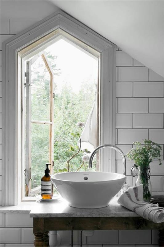 natūralus vonios kambario dekoras, baltas praustuvas, geometrinis langas, baltos metro plytelės