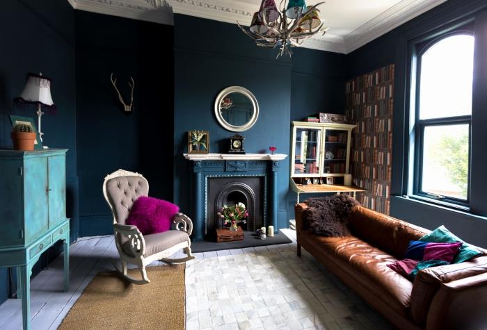 küçük vintage oturma odasına derinlik kazandıran petrol mavisi boya, turkuaz ve fuşya dokunuşlarıyla zenginleştirilmiş petrol mavisi boyalı duvarlara sahip oturma odası