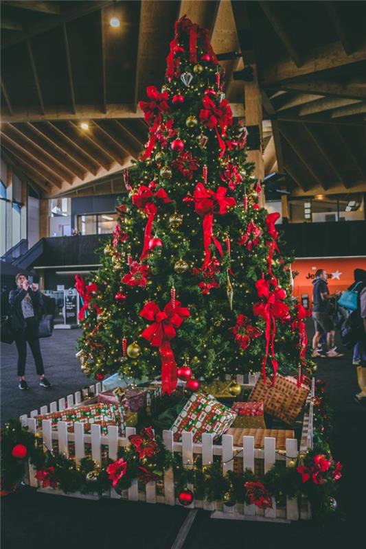 Ideja za okrasitev božičnega drevesa v božičnih kroglicah in rdečih trakovih ter več lučkah vejice limineuse