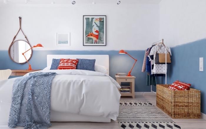 İskandinav evinde yatak odası, İskandinav beyaz yatak mobilyaları, beyaz, mavi ve kırmızı nevresimler, mavi ve beyaz duvar dekorasyonu, yuvarlak ayna, siyah beyaz halı, ormanda tilki çizimi duvar dekorasyonu