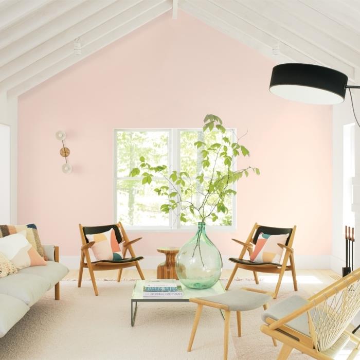 ahşap mobilyalar ve çok renkli minderler ile pembe duvarlı modern bir oturma odası nasıl düzenlenir