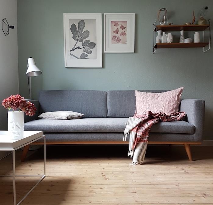 morsko zelena dnevna soba, senčnik celadon v barvah za stene, siv kavč, parket iz svetlega lesa, minimalistična klubska mizica, lesena in kovinska polica, skandinavski dizajn