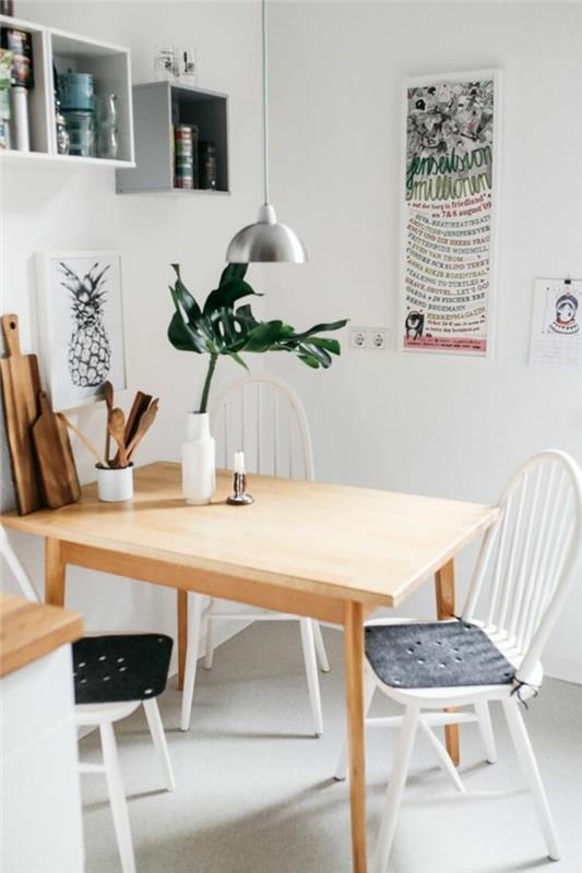 Piccola sala da pranzo con un tavolo di legno, parete decorata con scaffali and quadri artisti