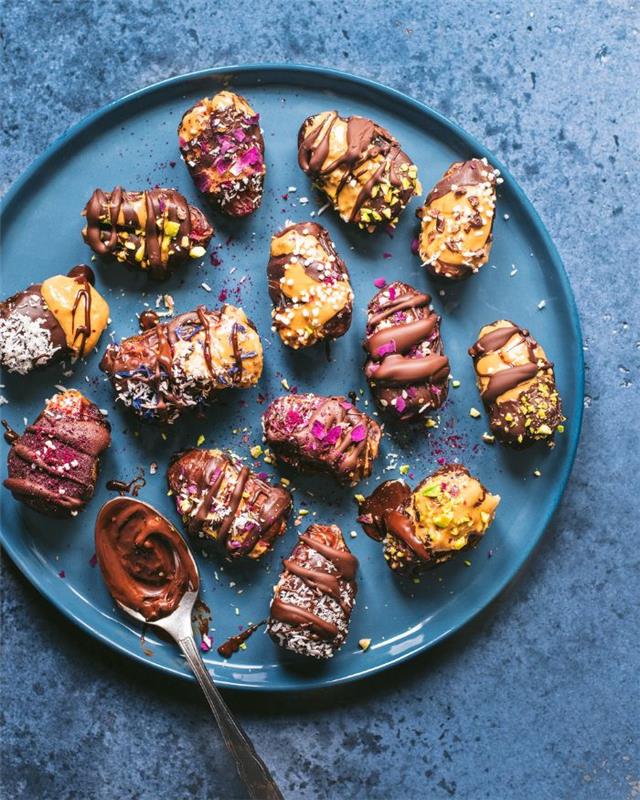 lengvas ir greitas dietinis desertas per kelias minutes, datulės, įdarytos žemės riešutų sviestu su kokoso įdaru, riešutai, valgomieji žiedlapiai ir šokoladas