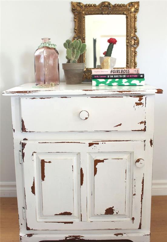 patina kos pohištva, ideja o majhni leseni mizi za shranjevanje, bela barva, knjige, rastlina, baročno ogledalo in deokrativna steklenica
