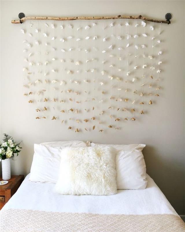 Vzglavje za glavo, vence iz lesa in belega papirja, bela posteljnina in bež odeja, elegantna dekoracija spalnice