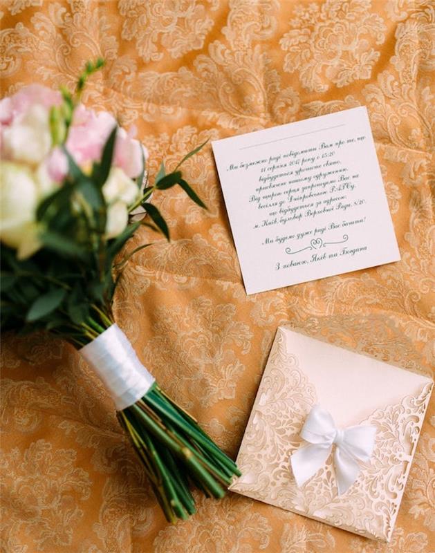 prašmatnus vestuvių kvietimas nėriniuotu baltu kaklaraiščiu ir kvietimo kortelė su kaligrafinėmis raidėmis