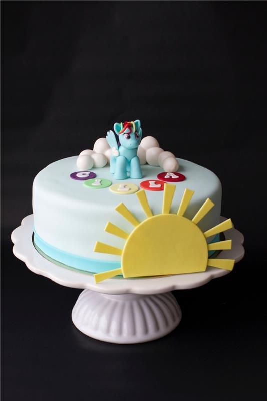 vaivorykštinio pyrago idėja vienaragio tema, padengta cukraus pasta ir dekoruota cukraus pastos modeliavimu