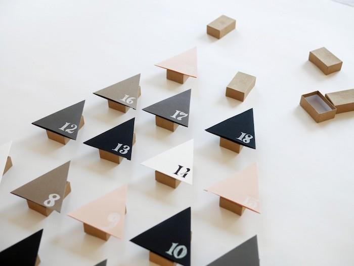kartoninė degtukų dėžutė su viena puse trikampio eglės pavidalu, sunumeruota baltais skaičiais, rankų darbo advento kalendorius