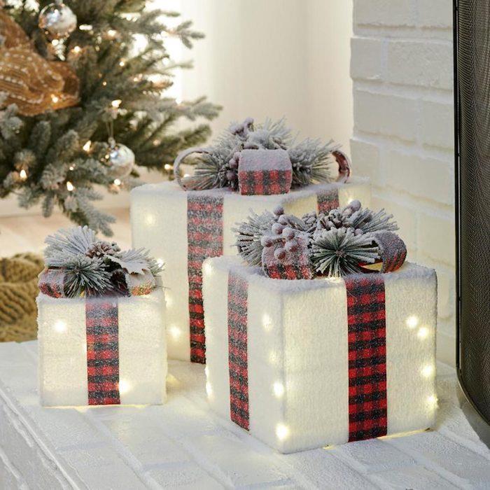 originali idėja apdailai padirbtu sniegu ir dekoratyviomis dovanomis priešais duris šalia šviečiančio medžio