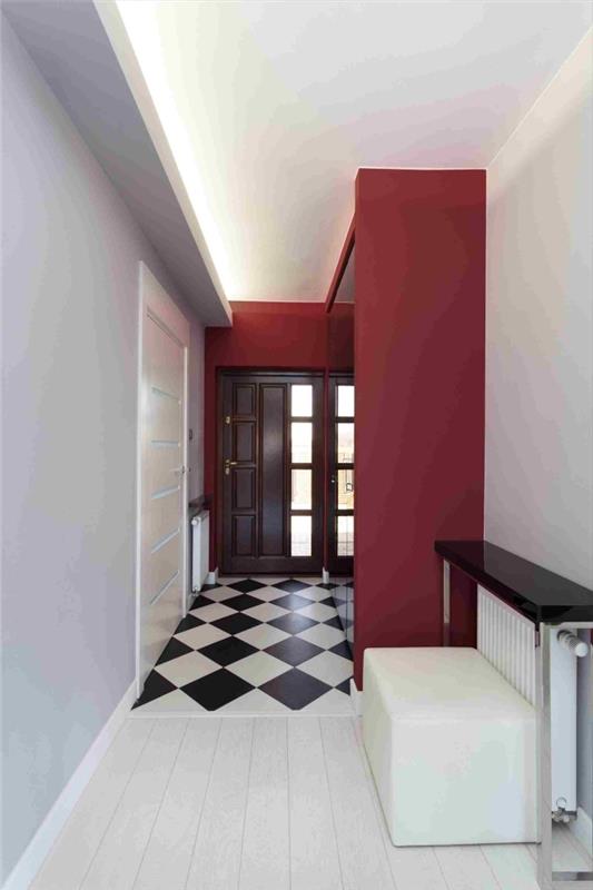 rdeč, bel in svetlo siv hodnik s črno -belim kariranim vinilnim podom