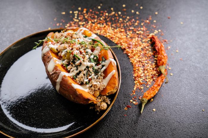 Cena sfiziosa, patata dolce con ripieno, peperoncino rosso secco, ripieno di quinoa e salsa bianca