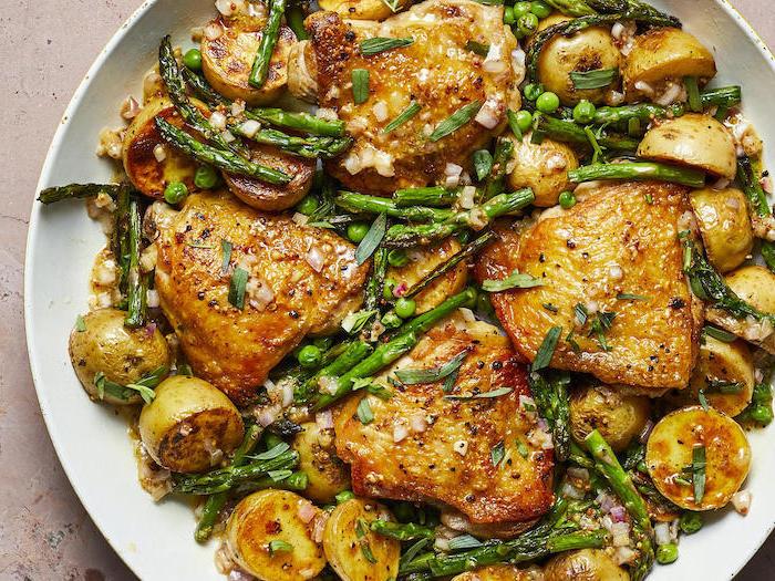 Pollo con patate, ali di pollo con asparagi, cena leggera invernale, piatto bianco rotondo
