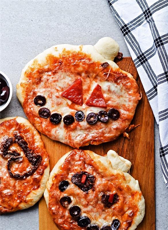 ürkütücü balkabağı cadılar bayramı pizzası, peynirli, domatesli ve zeytinli mini cadılar bayramı pizzası