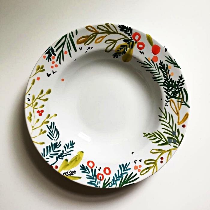 belo ploščo prilagodite s keramično barvo, na krožnik pobarvajte vzorce rastlin za božični dizajn
