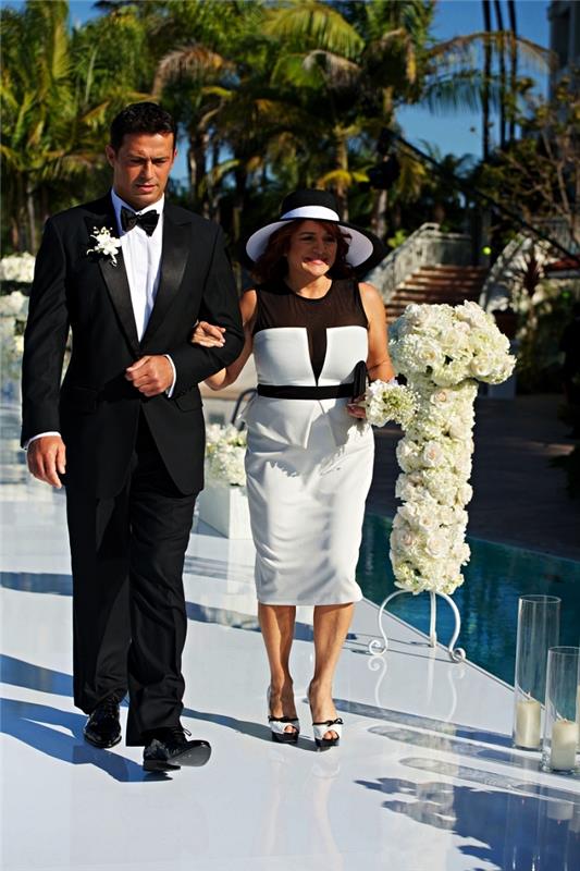 balta ir juoda peplum suknelė su juodo tiulio intarpu kartu su derančia vestuvine skrybėle, 50 metų vestuvinė suknelė nuotakos mamai