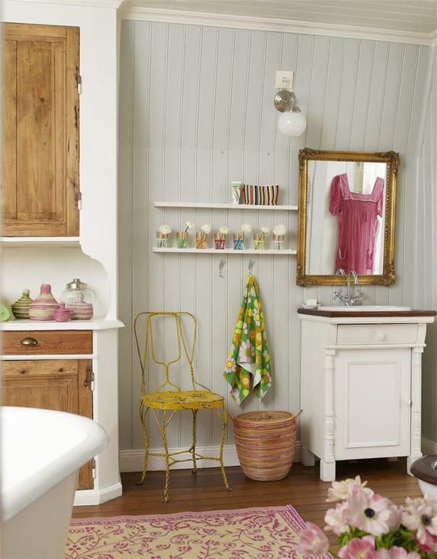 stara kopalnica z lesenimi oblogami in barvitimi dodatki s starinskim umivalnikom