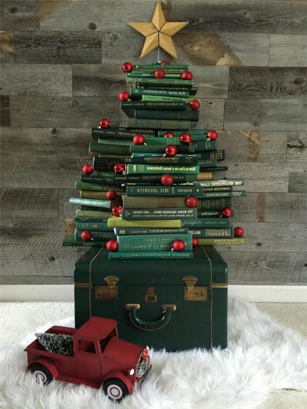 eski bir bavul ve rahat beyaz bir halının üzerine yerleştirilmiş, oldukça orijinal bir Noel ağacı oluşturan yeşil kapaklı eski kitap yığını