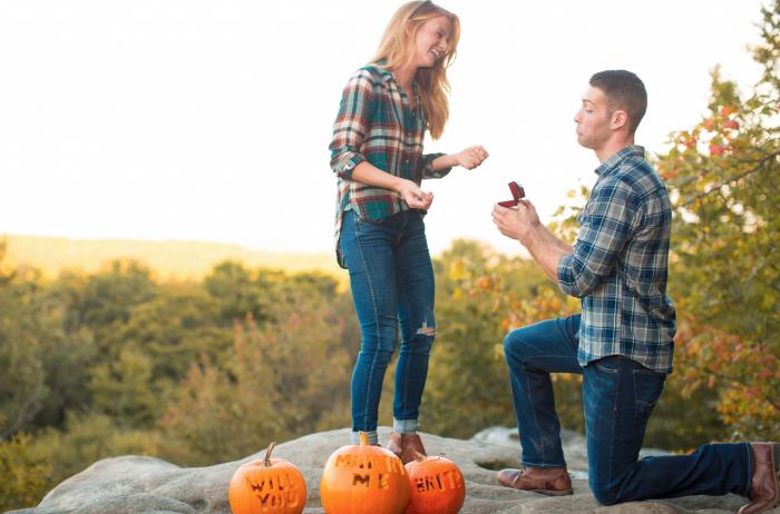 ideja za poroko presenečenja jeseni, besede se boš poročil z mano, vklesane na oranžne buče, predlog na majhnem hribu v gozdu