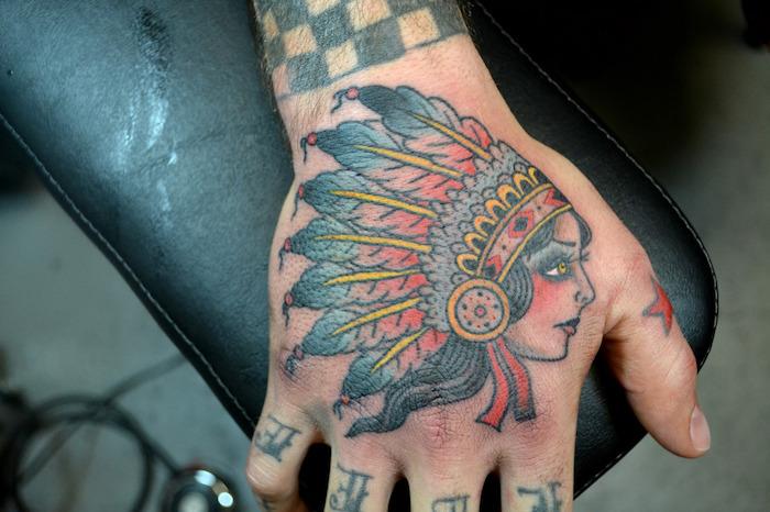 tetovaža roke, risba na koži v barvah in indijski dizajn, tetovaža ženske glave s perjem