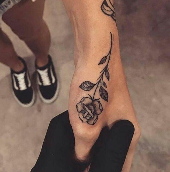 rožių rankos tatuiruotė, kylanti link nykščio pagrindo, įkvepiančios tatuiruotės, kurioje gausu simbolikos, pasirinkimas moteriai