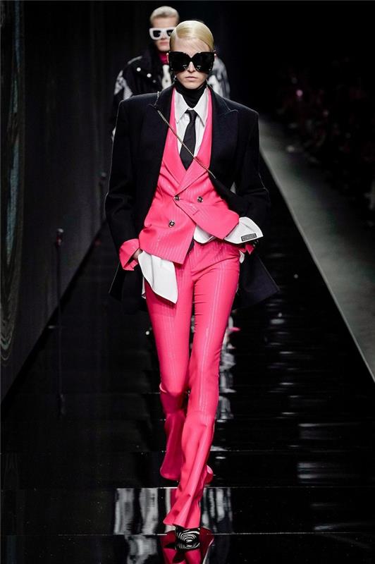 moters aprangos idėja biure su siuvėja ir rožine liemene be rankovių su švarku ir juodais akiniais