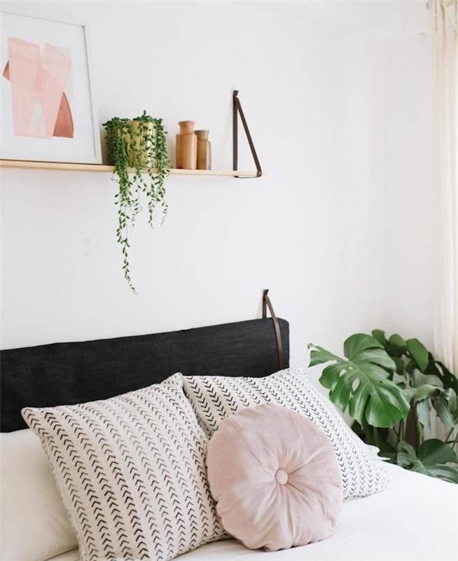 Naglavno glavo, lesena polica z okrasnim okvirjem, zelena rastlina in vaze, belo posteljnino s svetlo roza blazino