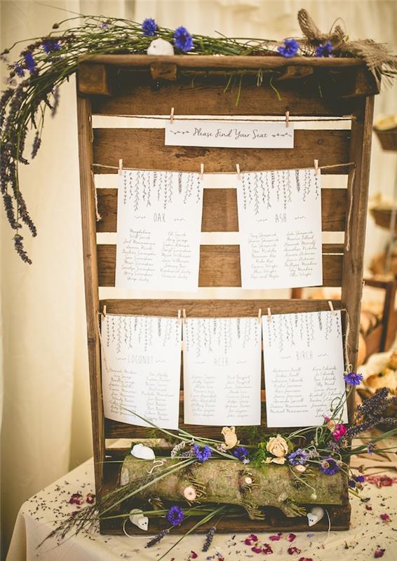 medinė dėžė su šalies puošmena, medienos ir kaimo gėlių rąstas, balti sąrašai su svečių vardais