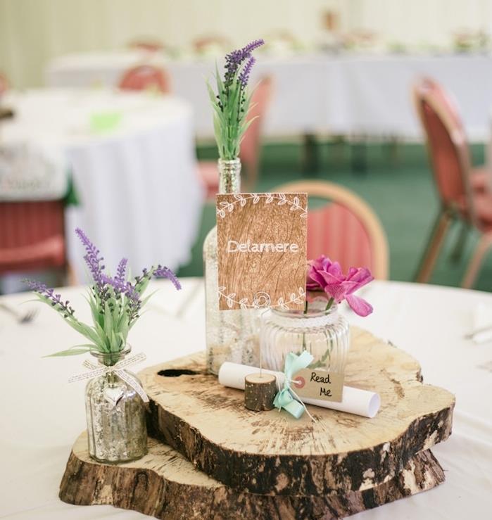 Ideje za poročno dekoracijo naredi sam, zloženi leseni hlodi, cvetlični stekleni kozarci, sivka, rožnato cvetje
