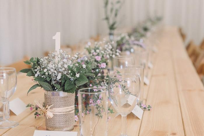 ideje za poročno dekoracijo, miza iz svetlega lesa, pločevinke za recikliranje, okrašene z juto z deželnimi cvetovi