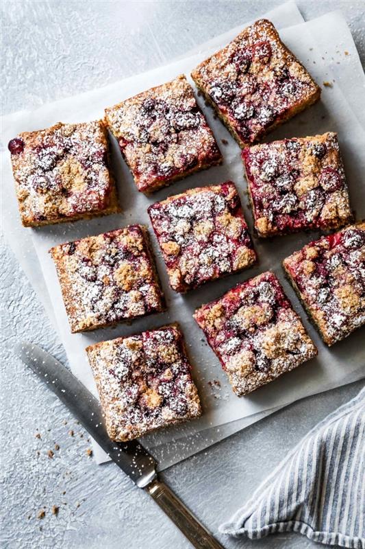 ideja za sladico brez glutena, recept za torto iz mehke brusnice in kardamoma, narezane na majhne kvadrate, posute s sladkorjem v prahu