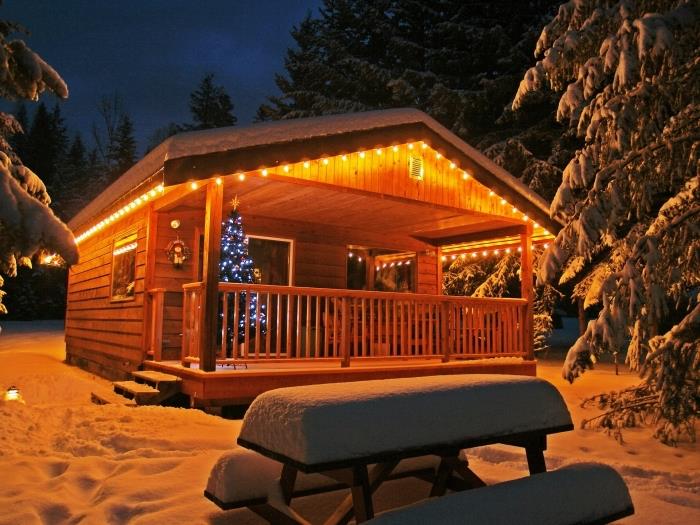 kokonuojantys kalėdiniai tapetai su apsnigta medine kabina ir papuošta Kalėdų eglute, naktinė namo snieguotame kalne nuotrauka