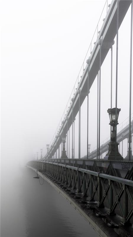 čudovita črno -bela podoba mostu, ki se izgubi v megli, fotografija mestne krajine, polna melanholije