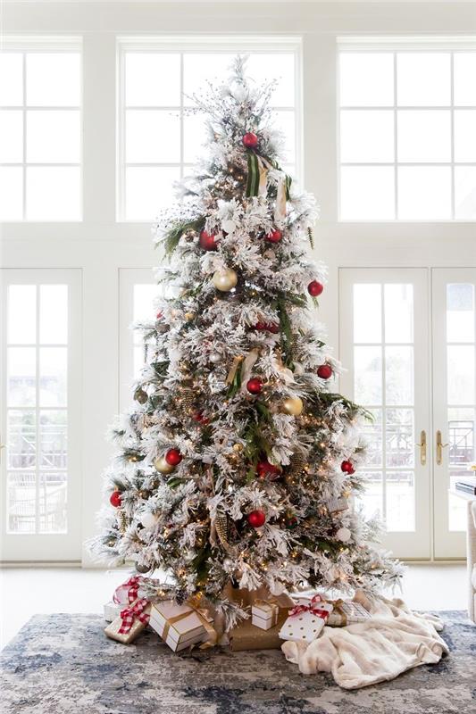slika božično drevo z zelenimi in belimi vejami z rdečimi in zlatimi kroglicami ter svetlobnimi venci okrasne noedus peids kot darilo